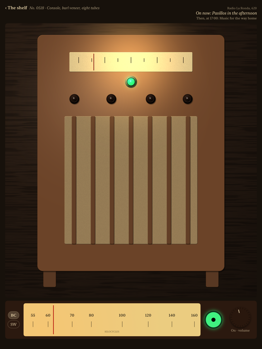 A 1939 console switched on: its dial glass lit, the pointer on 620, the green tuning eye closed on the station, and what Radio La Ronda has on now
