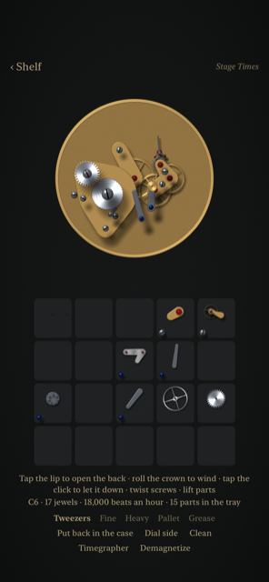 A chronograph movement half apart on the bench, its bridges lifted and lying in the numbered compartments of the parts tray below